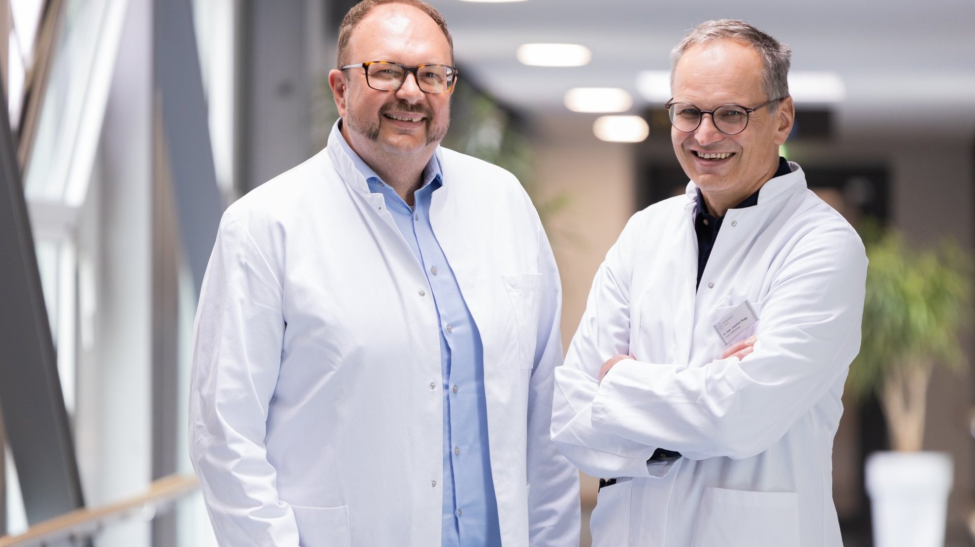 Dr. med. Roland Tines (links) und Dr. med. Joachim Rogg (rechts), Chefärzte des Fachbereichs Gefäßchirurgie am Klinikum Kempten auf einem Krankenhausflur