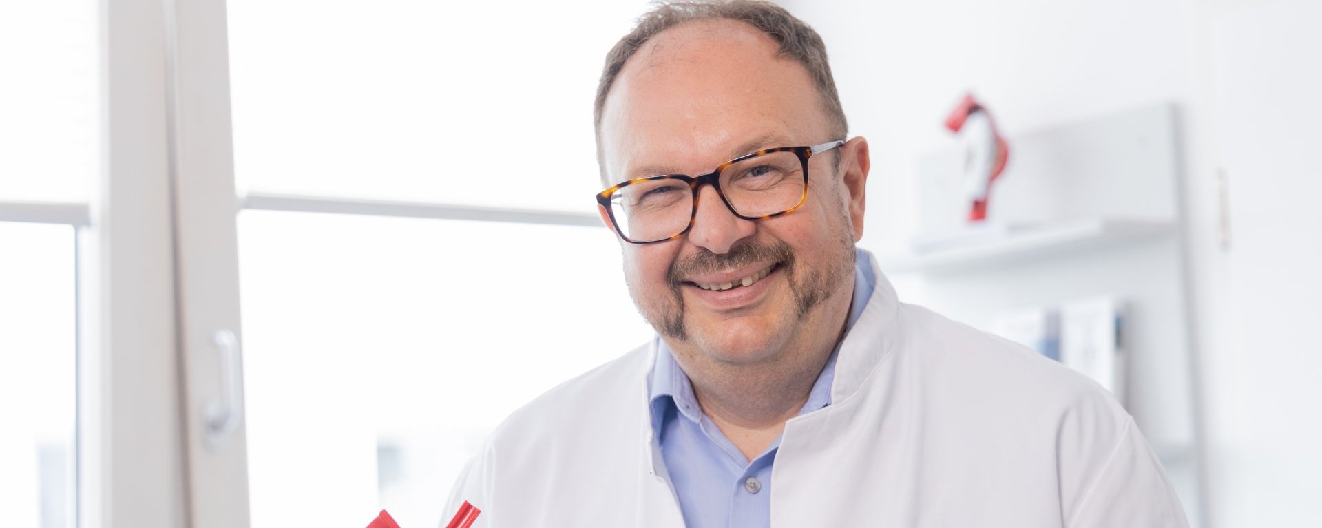 Dr. med. Roland Tines Facharzt, Chefarzt des Fachbereichs Gefäßchirurgie am Klinikum Kempten mit einem Modell des menschlichen Gefäßsystems
